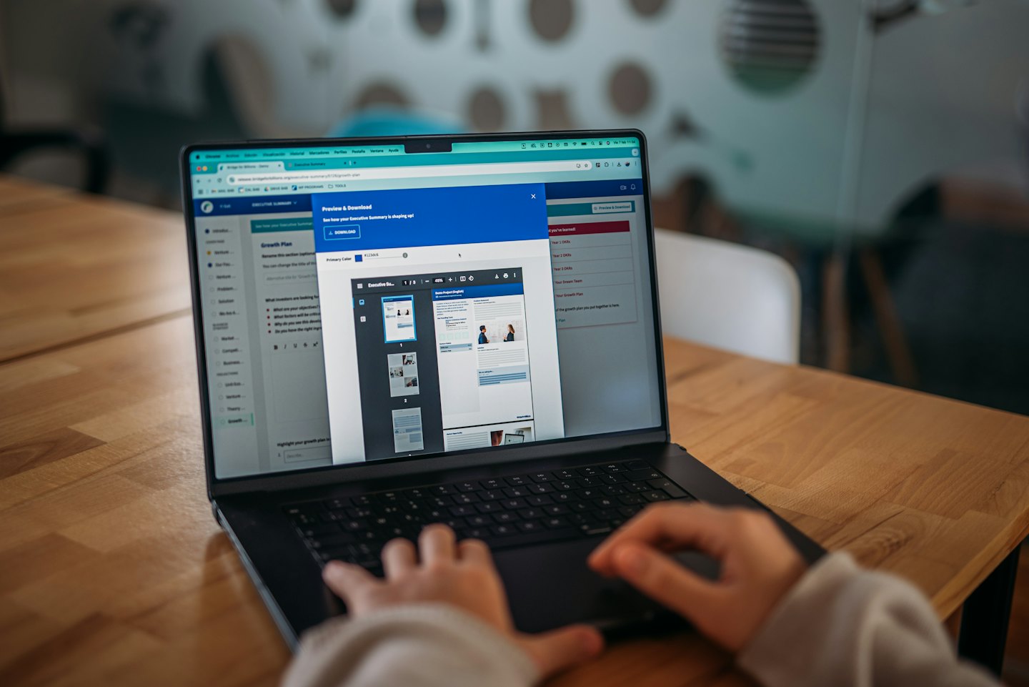 Mani che digitano su un laptop che mostra l'anteprima di un documento.